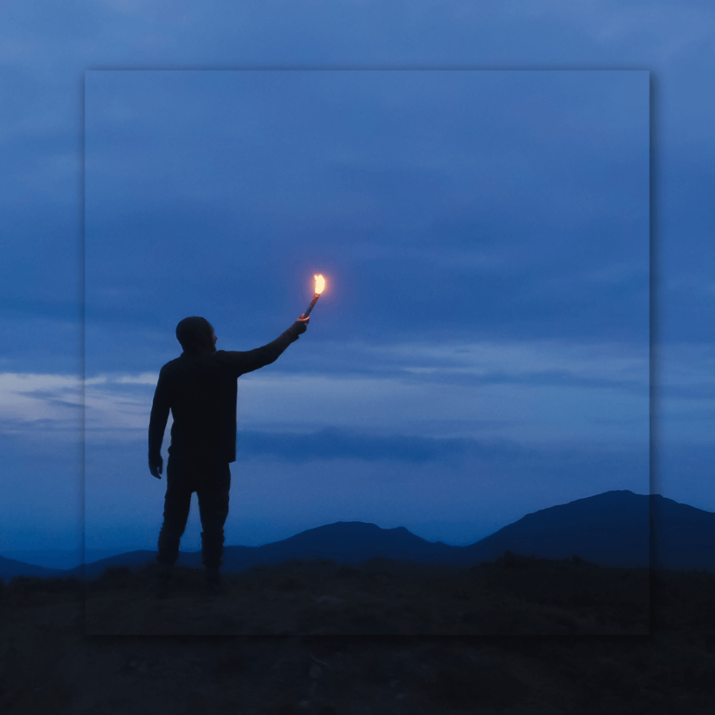 Silueta de una persona sosteniendo una luz en la oscuridad, simbolizando el avance y la esperanza. Miedo al fracaso