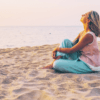 Mujer meditando en la playa, representando el poder del pensamiento positivo y la calma interior.